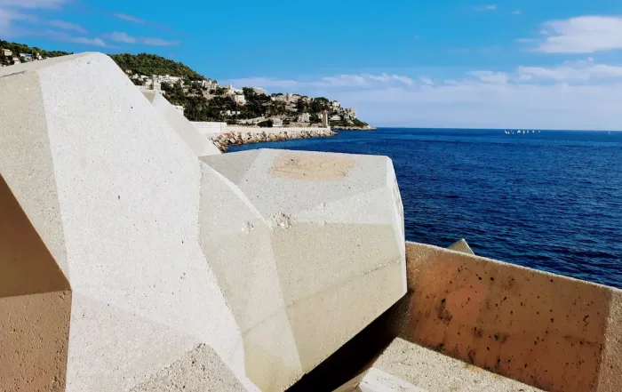 balade au port de nice le long des gros bloc de beton face au monument aux morts avec vue sur le mont boron