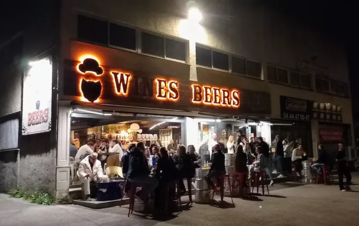 terrasse de l'etablissement wines beer a mougins la nuit tombee avec enseigne lumineuse