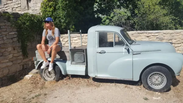 auteur du blog assise sur vieille voiture abandonnee servant de deco dans les rues de st martin de castillon un village de pierres dans le luberon