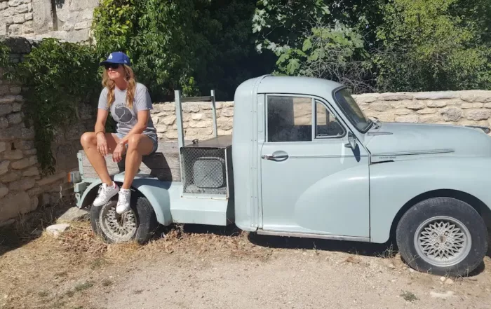 auteur du blog assise sur vieille voiture abandonnee servant de deco dans les rues de st martin de castillon un village de pierres dans le luberon